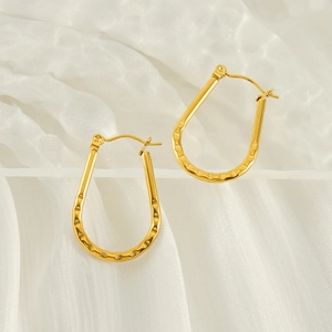 Chic 18K gold plated U-shaped titanium steel earrings with hammered texture on white silk
