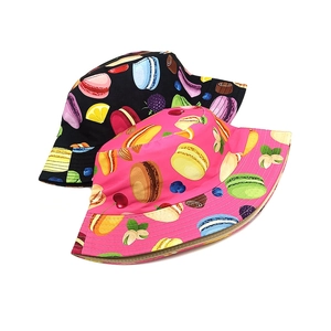 Close-up of kids bucket hats featuring colorful macaron and cherry print patterns