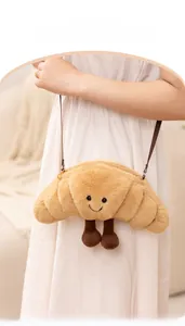 Enfant portant un sac bandoulière en peluche en forme de croissant avec un visage souriant