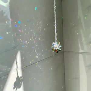 Detailed view of rainbow prisms reflected from a cut crystal flower suncatcher hanging
