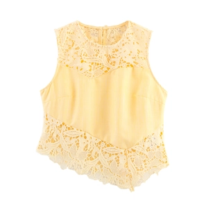 Detail of elegant yellow sleeveless top featuring intricate lace patchwork and round neck