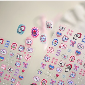 Detail of embossed cartoon nail stickers with cat, tulip, and bow motifs on a manicure set