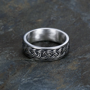 Vintage stainless steel wide band ring with silver celtic knot weave pattern on stone background