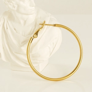 Classic 18K gold plated stainless steel hoop earrings on an elegant white plaster statue