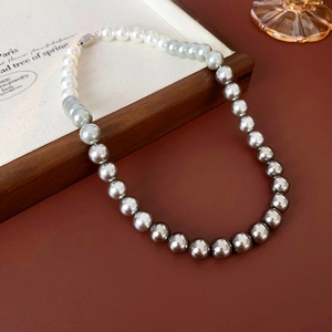 Detail of single row pearl necklace showing smooth gradient from white to dark grey pearls