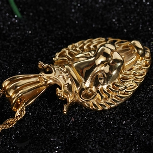 Macro detail of golden lion head pendant with crown on textured black background