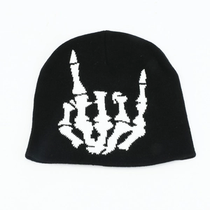 Détail du bonnet en maille noire avec motif jacquard blanc geste main squelette