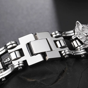 Detailed macro view of the silver mechanical bike chain clasp on a men's steel bracelet
