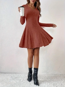 Detail of elegant V-neck knit mini dress with long sleeves and flared brick red skirt