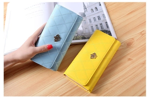 Close-up of diamond quilted PU leather wallets with crown buckle in blue and yellow