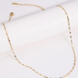Elegant gold link chain necklace with a minimalist lip pendant on a white pedestal