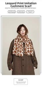 Detailed view of leopard print winter scarf with fringed edges on wool coat