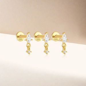 Close-up of three gold S925 sterling silver studs with sparkling rhombic zirconias