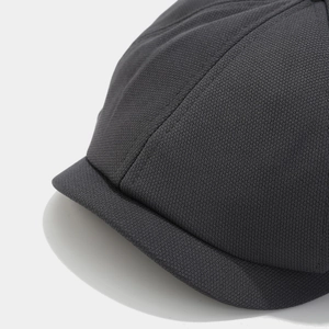 Close-up of the breathable dark grey mesh texture and fabric detail of the newsboy cap