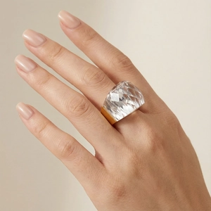Macro detail of faceted crystal ring with 18k gold plated band on model's hand
