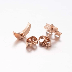Detail shot of rose gold star and moon stud earrings showing the back clasp and texture
