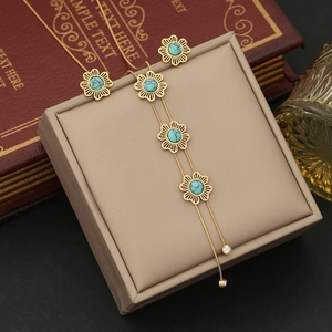Gold hollow floral jewelry set with turquoise stones and long tassel necklace details
