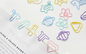 Close-up of assorted candy-colored metal paperclips in heart, star, and animal shapes