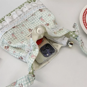 Detail view of mint green plaid canvas bag with magnetic closure and inner capacity