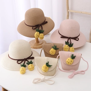 Détail d'un chapeau de paille et d'un sac bandoulière avec de jolis charms ananas tricotés
