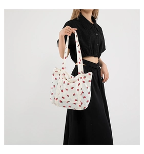 Detail of strawberry print tote bag showing thick corduroy texture and wide handles