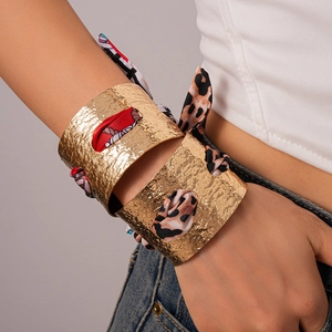 Dettaglio del bracciale a fascia martellato dorato con inserto in seta stampata