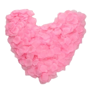 Pink silk rose petals for wedding decoration arranged in a romantic heart shape