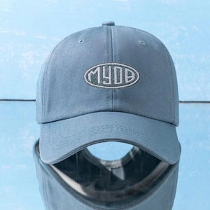 Close-up of MYDB embroidered logo on a light blue cotton baseball cap with ventilation holes