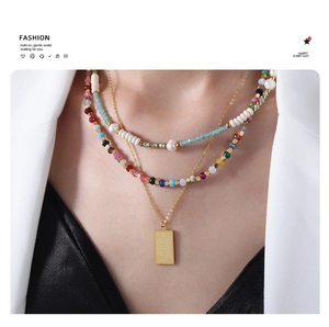 Detailed view of layered necklace with colorful tourmaline beads and golden plate