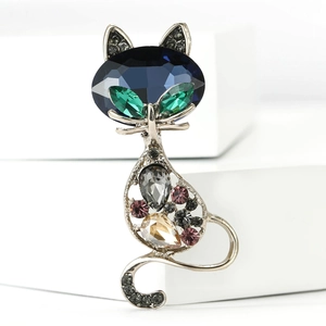 Detailed close-up of a vintage cat brooch with blue crystal head and colorful rhinestones