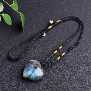 Detail of heart-shaped labradorite pendant with blue flash on black braided rope