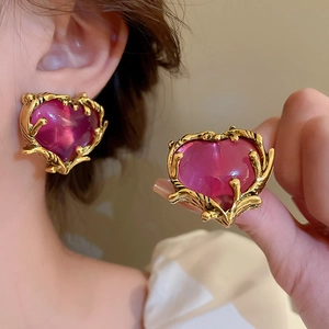 Detailed view of vintage gold plated heart earring featuring a purple crystal stone
