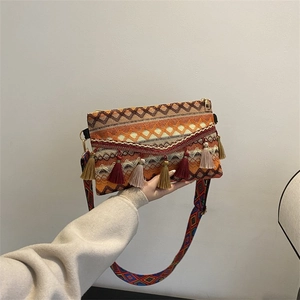 Detail of bohemian woven crossbody bag featuring colorful tassels and ethnic geometric patterns
