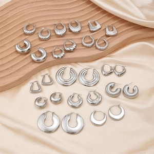 Irregular stainless steel earrings collection in silver finish on silk background