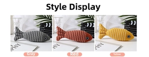 Detailed close-up of fish-shaped linen pet toys in gray, red, and yellow textured fabric