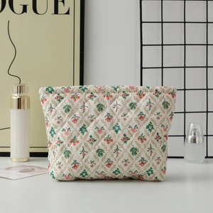 Detail of quilted floral makeup bag with elegant red flower and chain link patterns