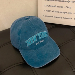 Detailed close-up of vintage blue washed cotton baseball cap with New York embroidery