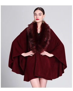 Detail of burgundy knit poncho with faux fox fur collar and wide sleeve cuffs