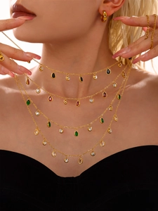Close-up of layered gold necklace with colorful teardrop zircons on a model