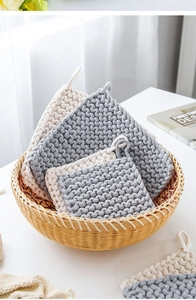 Detail of hand-woven square cotton rope coasters with storage loops in grey and white