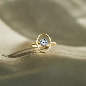 Close-up of gold S925 sterling silver evil eye ring with blue and clear crystals