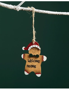 Detail of wooden gingerbread man pendant hanging on a branch with Welcome Friends text