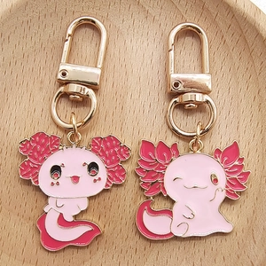 Détail de porte-clés axolotl en émail rose avec ferrures dorées sur bois
