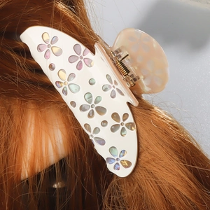 Pince à cheveux fleur crème élégante avec inserts nacrés sur de longs cheveux