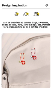 Détail des broches stéthoscope en émail rouge et cœur rose sur un sac en toile beige