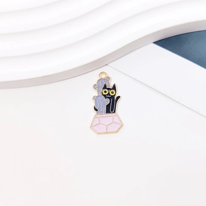 Close-up of black cat and blue cactus enamel charm for DIY jewelry and bracelets