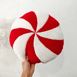 Detail of round red and white spiral candy plush pillow with soft sherpa texture
