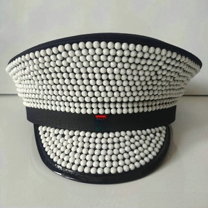 Detailed close-up of a black sailor cap featuring dense white pearl embellishments