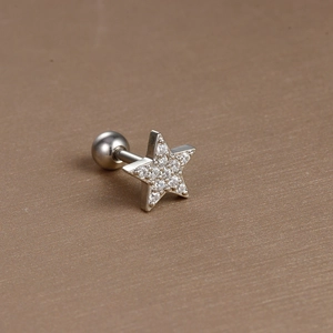 Detail of star-shaped stainless steel ear stud with cubic zirconia and screw back ball