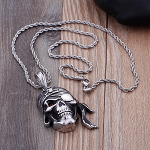 Détail du pendentif crâne de pirate en argent avec pierre rouge sur chaîne en acier